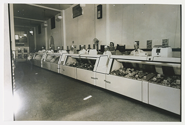 Black and white photo of a 1941 meat counter with workers standing behind.