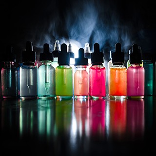 picture of several vials of colored liquid, smoke in background