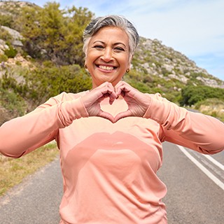 Smiling woman making heart sign