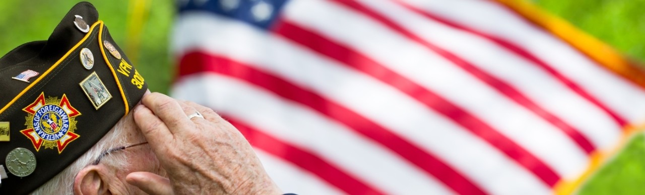 Veteran saluting a US flag